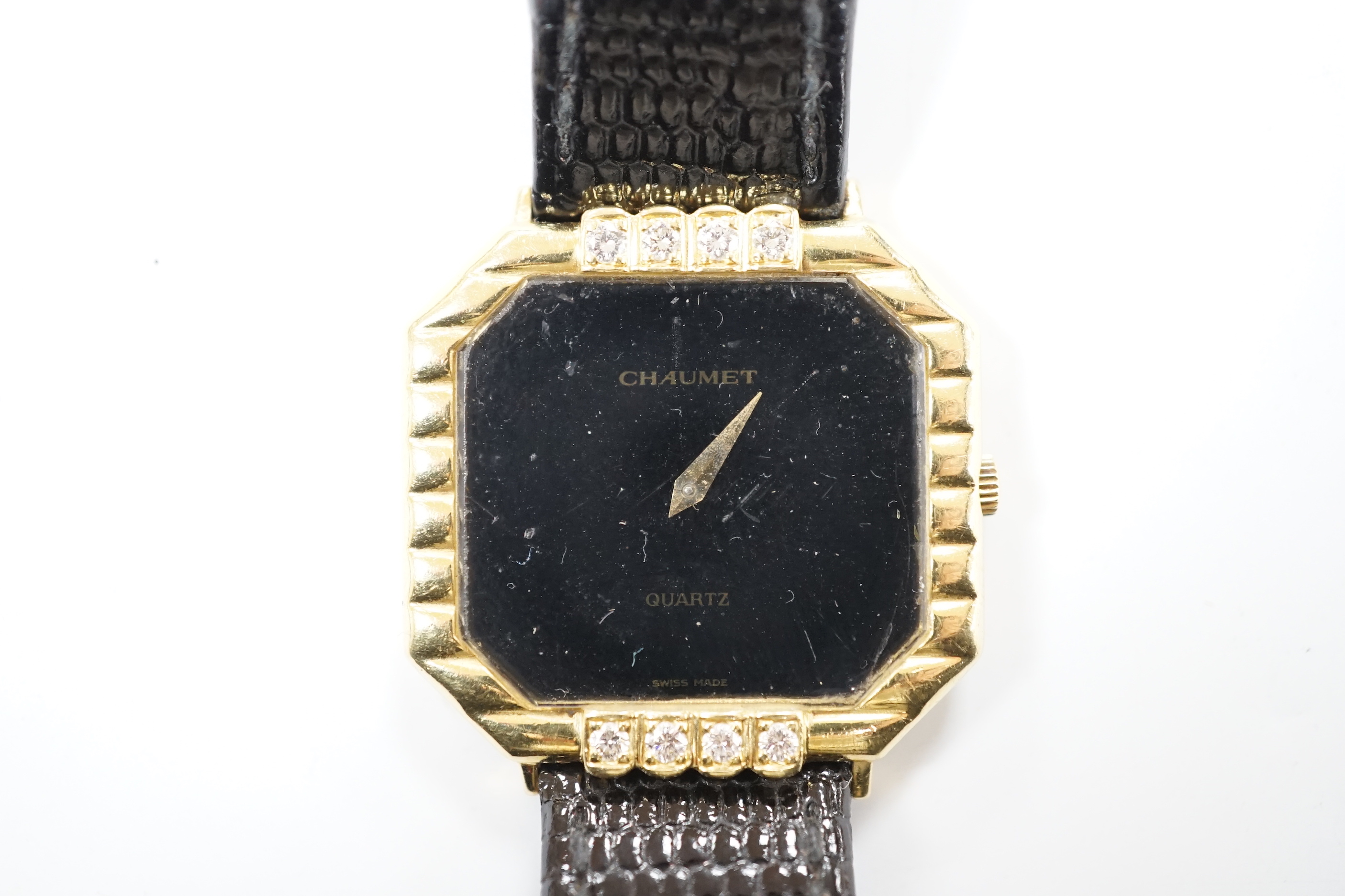 A lady's 18ct gold Chaumet quartz black dial dress wrist watch, with eight stone diamond set bezel, on an associated leather strap.